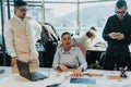 A diverse group of business employees engage in a meeting, discussing documents and strategies around a table.
