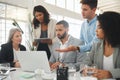 Diverse group of businesspeople having a meeting while standing together at a table at work. Business professionals Royalty Free Stock Photo