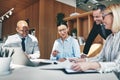 Laughing businesspeople going over paperwork together during an Royalty Free Stock Photo