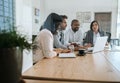 Businesspeople working on a laptop inside of an office boardroom Royalty Free Stock Photo