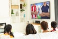 Diverse group of children siting on the couch and watching football match