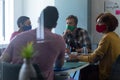 Diverse group of colleagues wearing face masks in office meeting Royalty Free Stock Photo