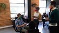 Diverse group of colleagues wearing masks having disussion in creative office Royalty Free Stock Photo