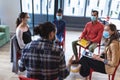 Diverse group of creative colleagues wearing face masks talking at meeting Royalty Free Stock Photo