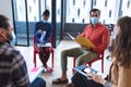 Diverse group of creative colleagues wearing face masks talking at meeting Royalty Free Stock Photo