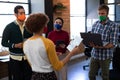 Diverse group of creative colleagues wearing masks having discussion in office Royalty Free Stock Photo