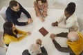 Religious people in Bible study group sitting around table and praying to God together Royalty Free Stock Photo