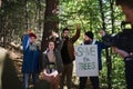 Diverse group of environmental activists with banner protestig against illegal construcion in forest