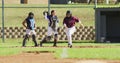 Diverse group of female baseball players playing on the field, happy hitter hitting ball and running