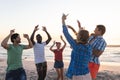 Diverse group of friends enjoy a beach sunset, with copy space Royalty Free Stock Photo