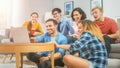 Diverse Group of Friends Use Laptop in the Living Room. Happy Beautiful Girls and Guys Doing Live Royalty Free Stock Photo