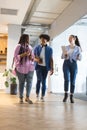 Diverse group of friends walking and talking together in a modern business office Royalty Free Stock Photo