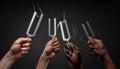 Unity in Vibration - Diverse Hands with Tuning Forks Royalty Free Stock Photo