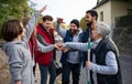 Diverse group of happy community service volunteers stacking hands together outdoors in street