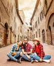 Group of friends eating ice-cream in old town center in Italy, travel and food concept