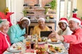 Diverse group of happy senior friends in holiday hats celebrating christmas together, taking selfie Royalty Free Stock Photo