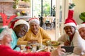 Diverse group of happy senior friends in holiday hats celebrating christmas together, taking selfie Royalty Free Stock Photo