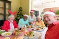 Diverse group of happy senior friends in holiday hats celebrating christmas together, taking selfie Royalty Free Stock Photo