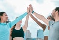 Diverse group of happy sporty people joining hands to high five for celebration of unity and support. Motivated athletes Royalty Free Stock Photo