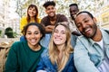Diverse group of happy young best friends smiling at camera sitting outdoors. Royalty Free Stock Photo