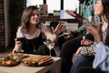 Diverse group of happy young people enjoying alcoholic beverage while telling childhood stories. Royalty Free Stock Photo