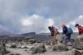 Diverse group of hikers trekking across the rugged terrain of Mount Kilimanjaro