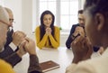 Diverse group of people praying to Lord sitting together around table with Bible Royalty Free Stock Photo