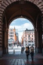 Diverse group of individuals traversing an impressive urban archway in Stockholm, Sweden