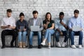 Diverse group of millennial people focused on different devices