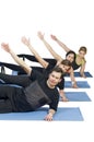 Diverse group of people in a gym class lying in a receding row o Royalty Free Stock Photo