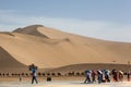 Diverse group of people heading to the Singing dunes and the Crescent Lake in the Kumtag Desert