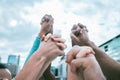 Diverse group of people holding hands with arms raised to express unity, support and trust. Multiracial people cheering Royalty Free Stock Photo