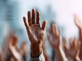 Diverse group of people raising hands together in unison symbolizing participation, unity, and collective decision-making during a Royalty Free Stock Photo