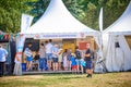 Diverse group of people standing near a tent of European Funds in a park in Poznan, Poland