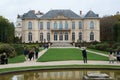 Diverse group of people are walking around a large, impressive Rodin Museum in France