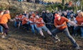 Diverse group of people working together to pull a rope during a game