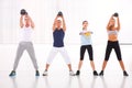 Diverse group practicing kettlebell exercise in crossfit gym