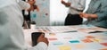 Diverse team collaborating around colorful sticky notes during a brainstorming session in a modern office environment Royalty Free Stock Photo