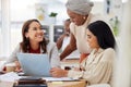 Diverse group of smiling business women using a laptop for a brainstorm meeting in an office. Happy confident Royalty Free Stock Photo