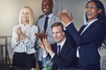 Diverse group of smiling businesspeople clapping after an office Royalty Free Stock Photo