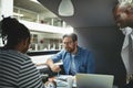 Smiling designers talking together in an office meeting pod