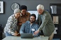 Diverse group of smiling senior people using laptop with man in computer class Royalty Free Stock Photo