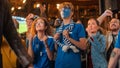 Diverse Group of Soccer Fans with Colored Faces Watching a Live Football Match in a Sports Bar Royalty Free Stock Photo