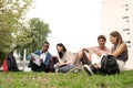 Diverse group of students sitting outside reading documents.Happy multiracial people studying sitting on the floor Royalty Free Stock Photo