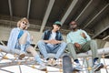 Diverse group of three young people hanging out in urban setting Royalty Free Stock Photo