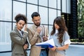 Diverse group of young business people outside office building, discussing and talking man and woman solving new construction plan Royalty Free Stock Photo