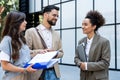 Diverse group of young business people outside office building, discussing and talking man and woman solving new construction plan Royalty Free Stock Photo