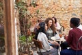 Female friends chatting over coffee in a trendy cafe courtyard Royalty Free Stock Photo