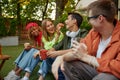 Diverse group of young people organizing picnic party outdoors