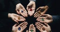 Top view of diverse hands forming a circle, each offering colorful gems and natural elements Royalty Free Stock Photo